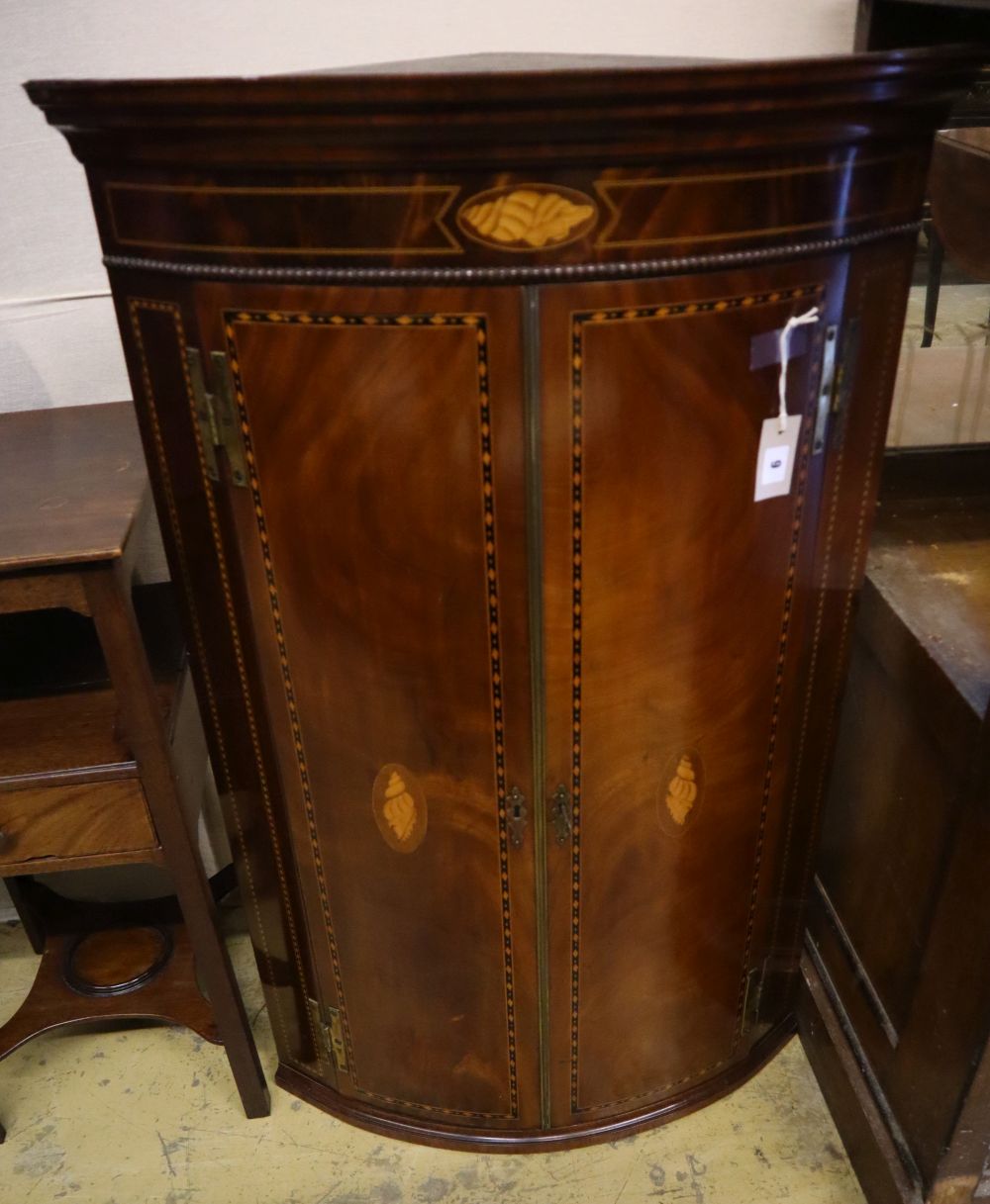 A George III inlaid mahogany bow-fronted hanging corner cupboard,